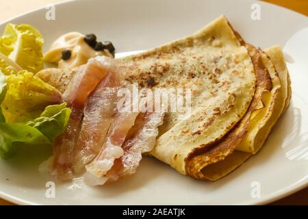 Gravlax con pancake servita foglie di insalata Foto Stock