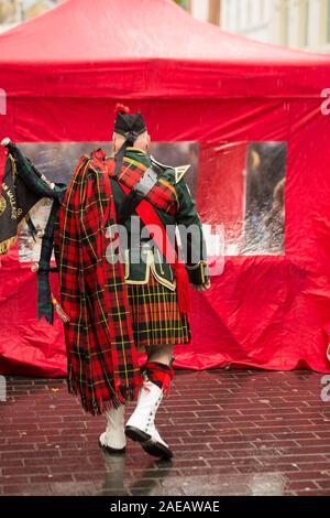 Un uomo vestito in costume nazionale della Scozia. Uomini della gonna. Sulla spalla di uomini in un grande rosso a scacchi sciarpa. Liverpool. In Inghilterra. Foto Stock