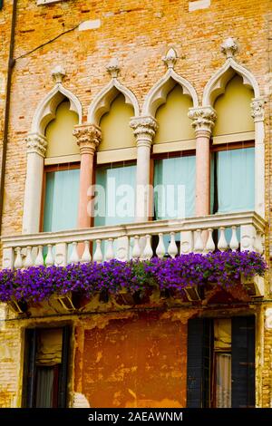 Vintage balcone con fiori viola, tipico di architettura di Venezia Foto Stock