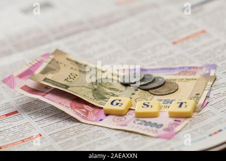 La GST e la tassa di farro usingscrabble fuori e la valuta indiana e note Foto Stock