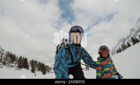 Bambino sciare nelle Alpi con i genitori. Ragazzo con suo padre. Selfie. Foto Stock