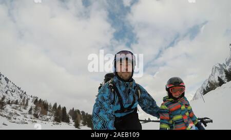 Bambino sciare nelle Alpi con i genitori. Ragazzo con suo padre. Selfie. Foto Stock