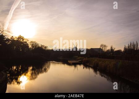 Il mulino a vento e il canale nel parco durante il tramonto in una fredda giornata invernale a Malmö, in Svezia Foto Stock
