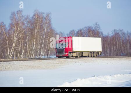 Grande carrello va sulla neve invernale autostrada Foto Stock