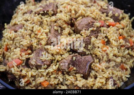 Pilaf è cotto sui carboni ardenti Foto Stock