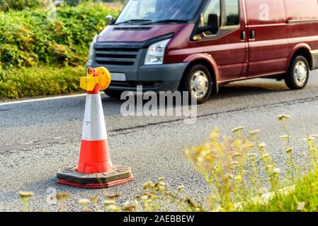 Vista tramonto uk servizi autostradali roadworks coni con red van passante Foto Stock