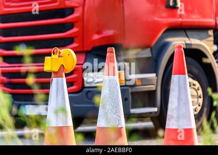 Vista tramonto uk servizi autostradali roadworks coni con red carrello passante Foto Stock