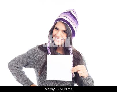 Ritratto di giovane donna con un maglione e peruviano di lana hat Holding firmano card . sfondo bianco . isolato Foto Stock