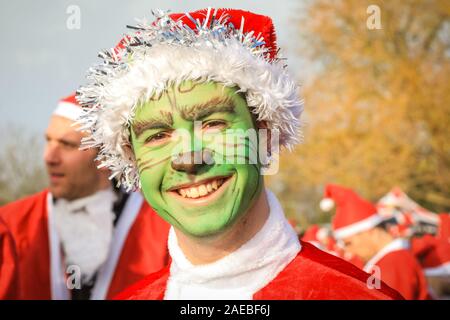 Brockwell Park, Londra, Regno Unito, 08 dic 2019. Il Grinch in spirito di festa. Attorno al 3000 Santa corridori vestiti da Babbo Natale partecipa all'annuale London Santa Dash 2019. Questo anno il 5k e 10k i percorsi per i corridori di tutte le età conduce attraverso Brockwell Park, Londra del sud. La Santa Dash alza il prezzo per dare bambini gravemente ammalati presso il Great Ormond Street Hospital (Gosh) la possibilità di un futuro migliore. Foto Stock