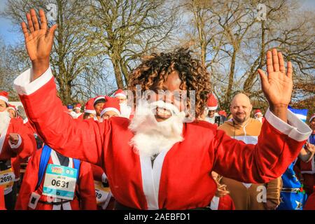 Brockwell Park, Londra, Regno Unito, 08 dic 2019. I Babbi Natale hanno un warm up prima della gara. Attorno al 3000 Santa corridori vestiti da Babbo Natale partecipa all'annuale London Santa Dash 2019. Questo anno il 5k e 10k i percorsi per i corridori di tutte le età conduce attraverso Brockwell Park, Londra del sud. La Santa Dash alza il prezzo per dare bambini gravemente ammalati presso il Great Ormond Street Hospital (Gosh) la possibilità di un futuro migliore. Foto Stock