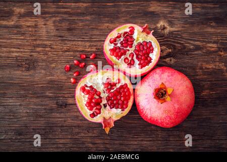 Mature e melograno fresco pelato e pronto per mangiare sulla beackground in legno. Foto Stock