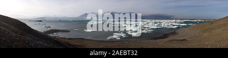 Vista panoramica del ghiacciaio Joekulsarlon laguna in Islanda. Gli iceberg dal ghiacciaio a sinistra lentamente deriva a destra fino a raggiungere il Foto Stock