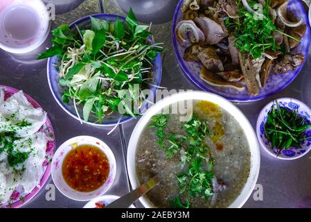 Farinata di riso con carne di maiale e bollito di maiale budella per colazione in Quy Nhon, Vietnam. Foto Stock