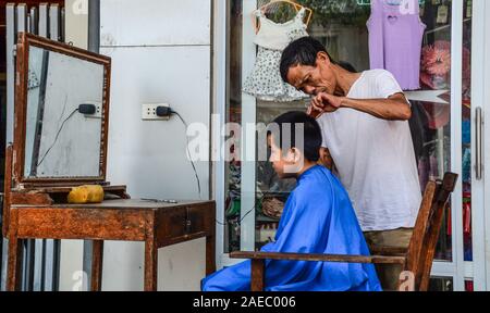 Lao Cai, Vietnam - 28 maggio 2016. Barbiere di strada a Bac Ha mercato nella città rurale di Lao Cai vicino a SAPA, Vietnam. Foto Stock