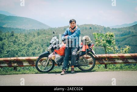 Asian traveler uomo con la moto su strada di montagna in Ha Giang, Vietnam. Foto Stock