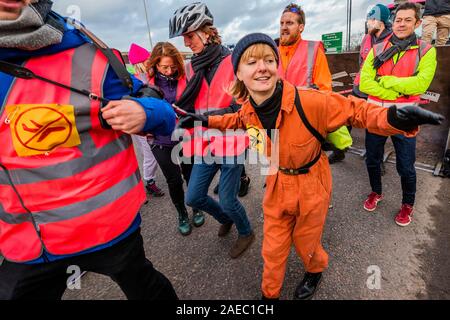 Londra, Regno Unito. 08 Dic, 2019. Una improvvisata danza dopo la bugia al warm up - estinzione della ribellione testa a Heathrow. Una massa critica di ciclisti in giro da Hyde Park Corner a Heathrow. All'aeroporto un bulldozer li unisce su Bath Road, sopra il Tunnel Road Roundabout e assieme svolgono un "Bulldozer lie-in" e agire fuori la distruzione futura bulldozer provocherà quando iniziano la costruzione del controverso terza pista. Boris Johnson è stato invitato, per dire come il sindaco che avrebbe fatto sdraiare davanti al primo bulldozer, per interrompere il lavoro su pista. Estinzione Rebellion dodici giorni di cri Foto Stock