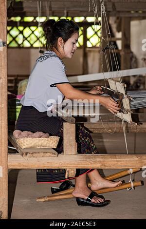 Giovani woamn tessitura su un tradizionale stile Lao-Thai telaio, divieto di Phnom, Laos Foto Stock