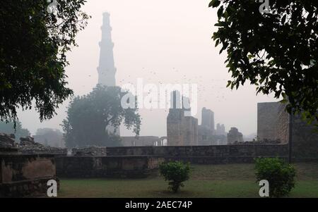Il Qutb Minar, minareto più alto del mondo, immersa nella foschia come dawn si rompe in Delhi, Uttar Pradesh, India. Foto Stock