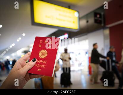 Close up della donna in possesso di un passaporto del Giappone all'aeroporto Foto Stock