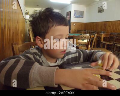 Ragazzo in un tradizionale kafenion greco Creta, Grecia. Foto Stock