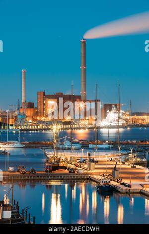 Helsinki, Finlandia - 10 dicembre 2016: Sera vista notturna della zona industriale di Hanasaari Power Plant e Pier, ormeggio con navi ormeggiate le navi. Praticamente Foto Stock