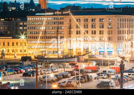 Helsinki, Finlandia - 10 dicembre 2016: Sera vista notturna di piazza del mercato e al traffico su Pohjoisesplanadi Street. Foto Stock