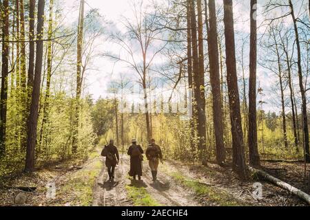 Gruppo di re-enactors vestito come Soviet russo Rosso esercito di soldati di fanteria della II Guerra Mondiale in marcia lungo la strada forestale a stagione primaverile. Foto Stock