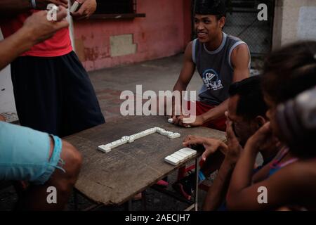 Caracas, Miranda, Venezuela. 30 Novembre, 2019. Giovani uomini giocare un gioco di domino. Una grave crisi sta accadendo nel paese Sud Americano del Venezuela. Un governo corrotto e massiccia inflazione ha provocato una grave crisi throghout il paese. Quelli nella baraccopoli di poveri soffrono pesantemente. La baraccopoli di Petare è uno dei settori che soffrono di più. Credito: Allison cena/ZUMA filo/Alamy Live News Foto Stock