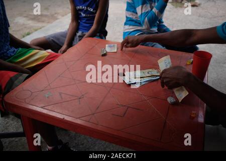 Caracas, Miranda, Venezuela. 30 Novembre, 2019. Gli uomini giocano un gioco che invloves scommesse su i numeri dei dadi. Una grave crisi sta accadendo nel paese Sud Americano del Venezuela. Un governo corrotto e massiccia inflazione ha provocato una grave crisi throghout il paese. Quelli nella baraccopoli di poveri soffrono pesantemente. La baraccopoli di Petare è uno dei settori che soffrono di più. Credito: Allison cena/ZUMA filo/Alamy Live News Foto Stock