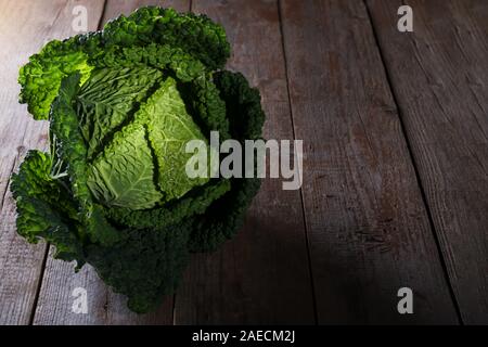 Fresh cavolo verza dal coltivatore organico farm su tavola in legno rustico, antiossidante cibo, mangiare sano e la dieta concetto chiave di basso Foto Stock
