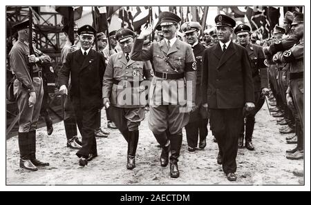 Vintage degli anni trenta parata nazista Adolf Hitler tenendo salutate da truppe a una struttura navale cerimonia con Martin Bormann sul suo lato destro la Germania Foto Stock