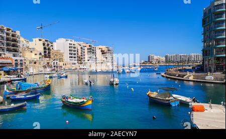 Spinola bay con barche di pescatori a St Julians, Malta, Europa Foto Stock