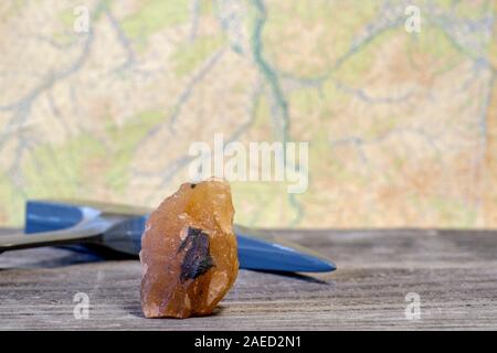 Il geologo del martello minerale e sono disposti su una tavola di legno contro una cartina topografica. Sfondo. Foto Stock