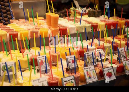 Un enorme varietà di succhi di frutta naturali sul display e per la vendita in al Mercado de la Boqueria di Barcellona. Foto Stock