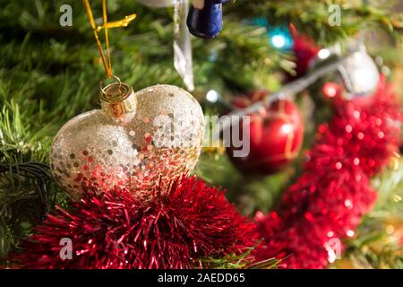 Forma di cuore ninnolo oro glitter albero di Natale ornamento, dettaglio, vicino. Foto Stock