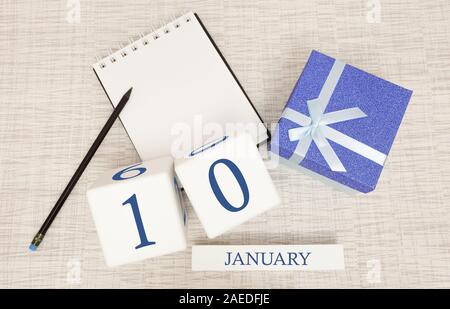 Calendario con blu alla moda di testo e numeri per gennaio 10 e un regalo in una scatola. Foto Stock