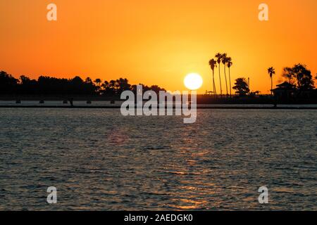 Scenic tramonto con sagome di palme lungo la riva, visto da sud Corniche a Jeddah, Arabia Saudita Foto Stock