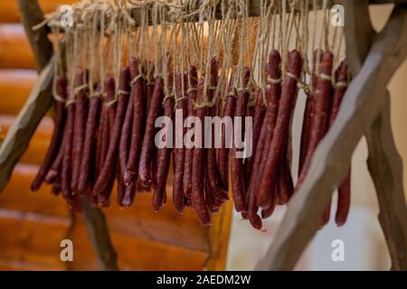 La caccia tradizionale salsicce sul tavolo. Riunione di famiglia per la conservazione di alimenti, la carne di maiale e la carne di cervo da un cacciatore locale. Foto Stock
