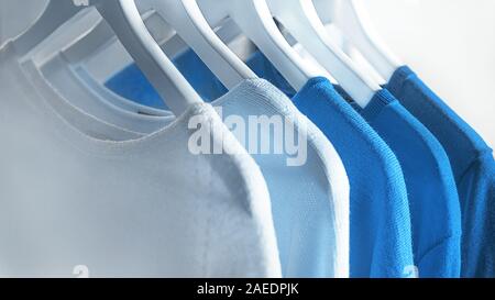 Vestiti su appendiabiti nei colori dell'anno 2020. Blu classico colore dell'anno 2020. Magliona, felpe nel classico colore blu. Foto Stock