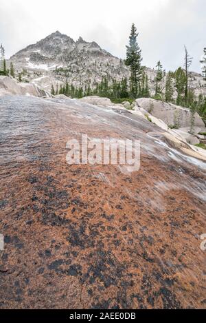 Flusso che scorre verso il basso una lastra di roccia in Idaho Le Sawtooth Mountains. Foto Stock