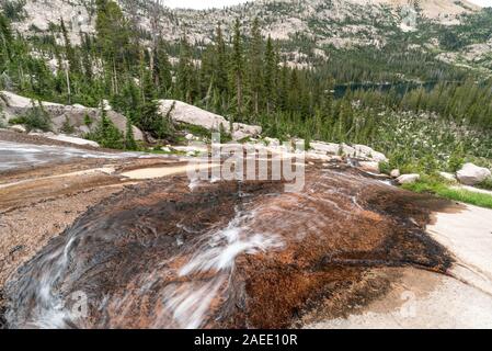 Flusso che scorre verso il basso una lastra di roccia in Idaho Le Sawtooth Mountains. Foto Stock