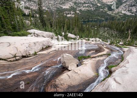 Flusso che scorre verso il basso una lastra di roccia in Idaho Le Sawtooth Mountains. Foto Stock