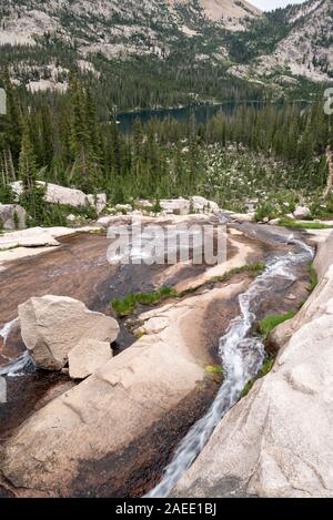 Flusso che scorre verso il basso una lastra di roccia in Idaho Le Sawtooth Mountains. Foto Stock