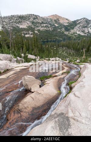 Flusso che scorre verso il basso una lastra di roccia in Idaho Le Sawtooth Mountains. Foto Stock