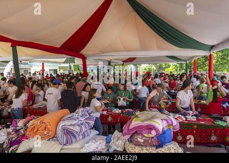 Caracas, Miranda, Venezuela. Il 7 dicembre, 2019. Centinaia di volontari organizzare i vestiti e giocattoli per essere donati. Santa en las calles è un venezuelano organizzazione senza fini di lucro che aiuta i più bisognosi attraverso la raccolta non monetaria dei beni che forniscono la felicità, protezione e sollievo per le loro esigenze di base. Ogni anno il primo fine settimana di dicembre si celebra un giorno di attività per cui migliaia di volontari ricevono donazioni per essere consegnati alle famiglie a basso reddito le aree e le istituzioni e per i senzatetto per le strade di Caracas. Credito: Jimmy Villalta/ZUMA filo/Alamy Live News Foto Stock