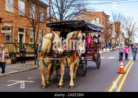 Gettysburg, PA / STATI UNITI D'America - 7 Dicembre 2019: una a cavallo il carro trasporta i partecipanti all'annuale festa di natale nella zona del centro citta'. Foto Stock