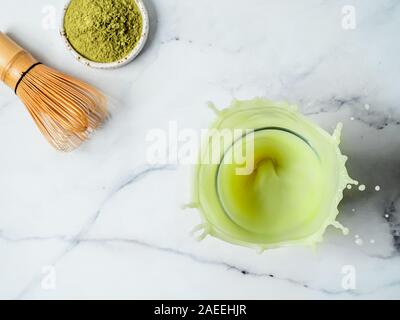 In casa iced matcha latte con spruzzi di colore bianco su sfondo marmo. Vista superiore piatta o laici. Copia spazio per il testo o per la progettazione Foto Stock