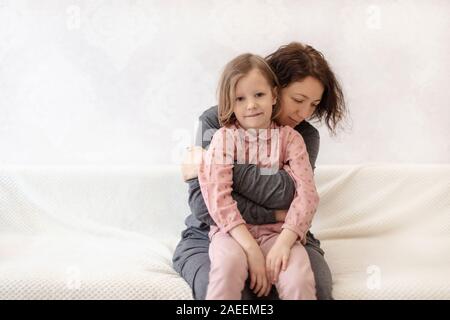 Giovane donna con sua figlia sono in appoggio sul divano. Messa a fuoco selettiva. Foto Stock