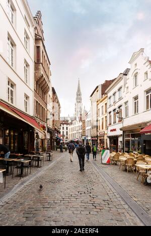 Una strada a Bruxelles con molti ristoranti e il Bruxelles Municipio torre in background, Belgio Foto Stock