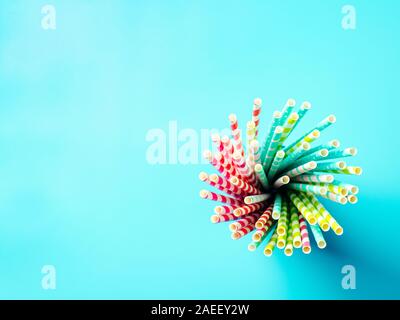 Vista dall'alto di carta colorata di bere cannucce su sfondo blu. Copia spazio per il testo o il design. Vista superiore piatta o laici. Foto Stock